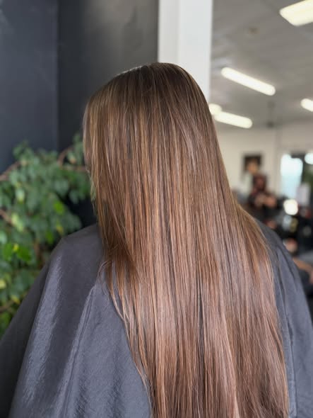 Brunette with sun-kissed highlights, long and sleek